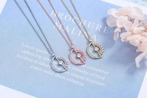 Detailed view of rotating moon and star pendants in silver, gold, and rose gold finishes
