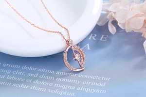 Macro view of rose gold sun and moon pendant with shimmering pave-set cubic zirconia
