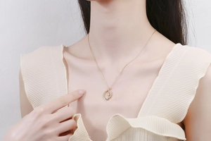 Close-up of a rotating celestial sun moon pendant necklace on a gold chain