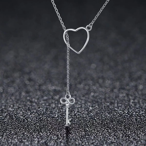 Detail of silver key pendant with infinity design and heart sliding buckle on Y necklace