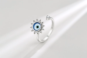 Macro detail of silver evil eye spinning ring with blue zircon and adjustable open band