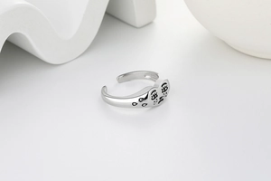 Vue macro de la bague coeur avec visage triste en argent vintage au fini poli