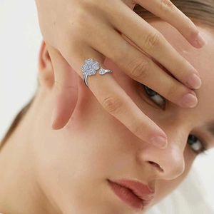 Close-up of rotatable clover spinner ring with zircons worn on model finger