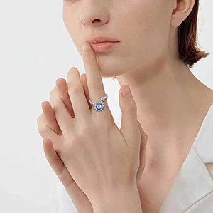 Detailed shot of an adjustable silver Evil Eye spinner ring worn on a finger