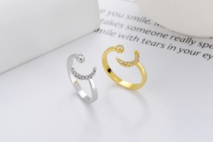 Detail of adjustable star and moon rings with zircon accents in gold and silver