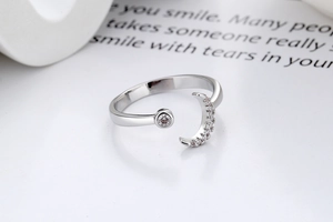 Close-up of adjustable moon ring with sparkling cubic zirconia on a paper background