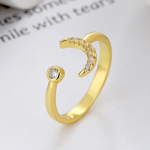 Minimalist gold moon open ring with white zircon stones on a white background