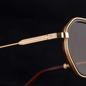 Detailed close-up of premium metal hinges and brown textured frames on polygon sunglasses