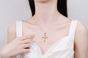 Nahaufnahme der goldenen Kreuzkette mit funkelnden Zirkonia und feiner goldener Kette