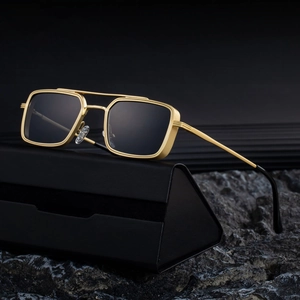 Classic metal square frame sunglasses with gold finish and dark lenses on a case