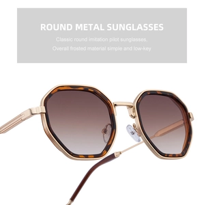 Close-up of polygonal metal sunglasses with tortoise shell texture and brown gradient lens