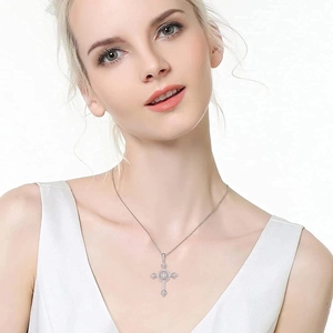 Nahaufnahme einer silbernen Kreuzkette mit Diamanten am Schlüsselbein eines Models