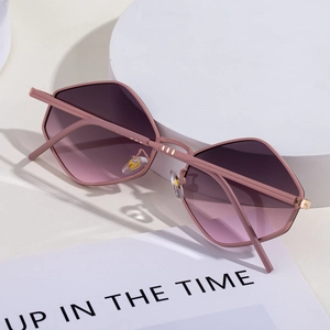 Close-up of pink hexagonal sunglasses with purple gradient lenses and metal hinges
