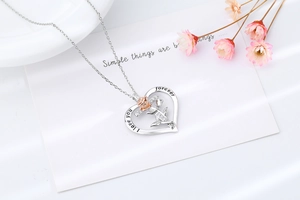 Détail du pendentif cœur avec fleur en or rose, croix et gravure I love you forever