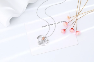 Détail du pendentif cœur bicolore avec croix et gravures I love you et Forever