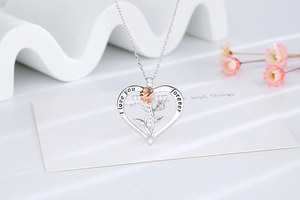 Détail du pendentif cœur avec rose dorée et gravure I love you forever sur l'anneau