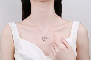 Détail du collier coeur avec rose et croix sur le cou du mannequin avec gravure