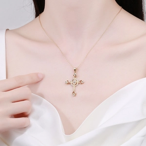 Elegante goldene Kreuzkette mit funkelnden Steinen auf weißem Seidenhintergrund
