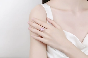 Gros plan d'une bague en pierre rose ovale avec micro-pavage de diamants au doigt