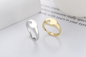 Detail of adjustable gold and silver signet rings with engraved star and zircon inlay