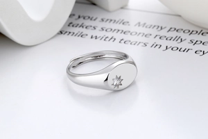 Macro shot of silver adjustable star ring with polished finish and central zircon