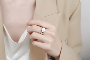 Detail of silver signet ring with engraved star pattern worn by professional model
