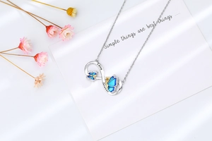 Detail of infinity butterfly necklace pendant featuring Love Forever blue gradient wings