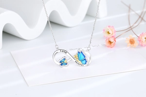 Macro view of infinity butterfly pendant with blue enamel and Love Forever engraving