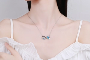 Close-up of infinity butterfly necklace with blue enamel and LOVE Forever engraving