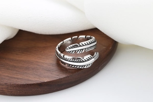 Macro detail of retro feather open ring with vintage oxidized silver leaf texture