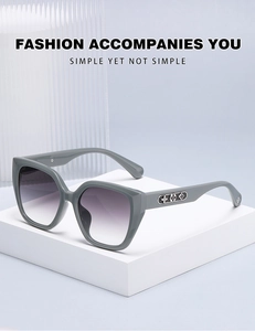Detail of grey cat-eye sunglasses with purple gradient lenses and floral metal decor