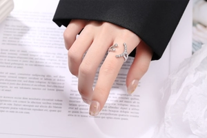 Detail of elegant S925 sterling silver wrap ring with white zircons on finger