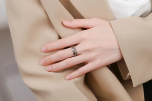 Détail d'une bague nœud vintage en argent avec émail noir et blanc au doigt