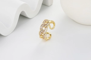 Macro shot of gold hollow chain ring with baguette and round cubic zirconia inlays