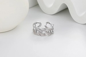 Macro detail of silver link chain ring encrusted with white pavé cubic zirconia diamonds