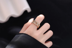 Detail of gold-plated chain link ring featuring pavé-set diamonds on a model's finger