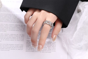 Macro view of a silver-toned chain ring with pavé-set stones on a female finger