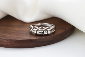 Macro shot of silver anti-anxiety ring with spinning beads and layered wave design