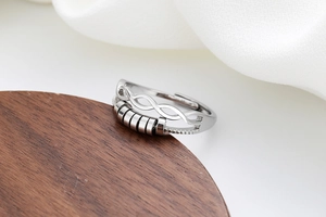 Detail of silver infinity fidget ring with rotatable beads and adjustable open band