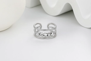 Macro detail of triple layer fidget ring featuring five sliding beads on silver band