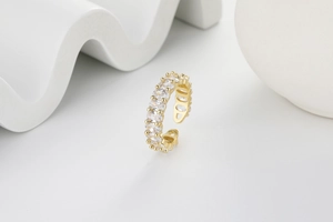 Detailed macro view of gold-plated adjustable ring featuring oval-cut cubic zirconia stones