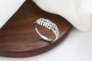 Detail of silver spinning ring with rotating geometric beads and hollow woven design