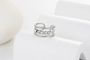 Macro detail of silver fidget ring with three-layer rope texture and movable beads