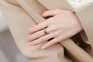 Detail of a rotating geometric silver ring with a checkered texture on a female finger