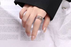 Close-up of triple-layered silver fidget ring with rotating beads on a book