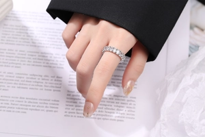 Detail shot of a silver geometric cubic zirconia ring on finger against book background