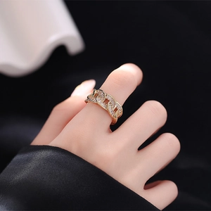 Luxurious gold chain ring with sparkling paved zircons shown on a hand with black background