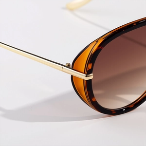 Macro shot of gold metal hinges and amber tortoise frame on retro aviator sunglasses