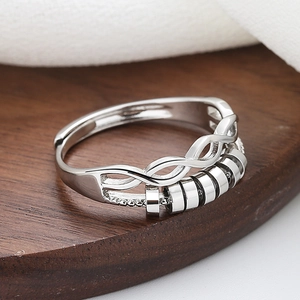 Adjustable silver fidget ring with interlocking lines and five rotating beads for anxiety