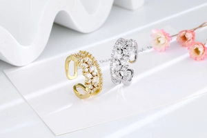 Detail of gold and silver adjustable rings with marquise-cut cubic zirconia inlay